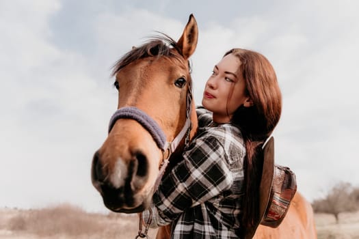 Cute happy young woman with horse. Rider female drives her horse in nature on evening sunset light background. Concept of outdoor riding, sports and recreation.