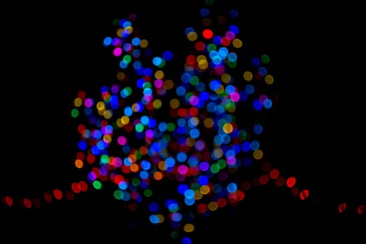 Colorful group of holiday lights on dark background of night