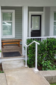 Entrance porch of residential unit with wooden bench at the door