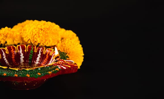 Elegance in Diwali, A stunning Diwali lamp and ornate flower rangoli set against a striking black backdrop. Perfect for Diwali, wedding invitations, and cultural celebrations.