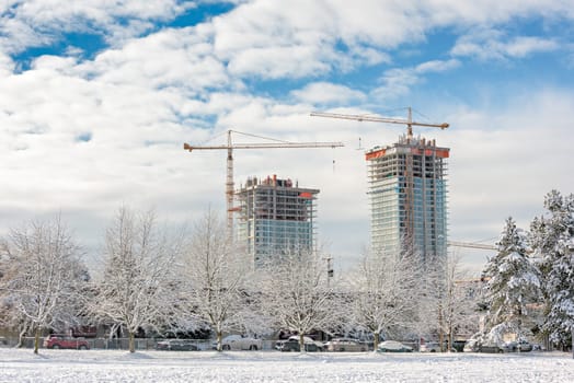 New high-rise residential buildings under construction on bright winter day.