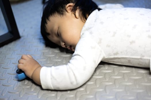 Little baby boy lying on the floor. Boy Sleeping On Floor With Car Toy In His Hand