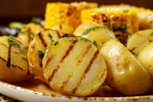 Grilled baked potatoes with corn, on a large frying pan. Food court