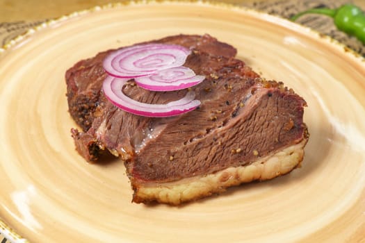 Beef steak close-up with onions. Concept of tasty food. Serving dishes in the restaurant