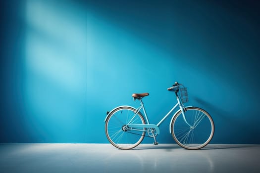 Blue bicycle with a basket in an empty room near a blue wall.
