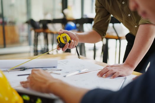 engineers discuss building on blueprint drawing, design building Project in office