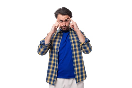 well-groomed brunette brutal man with a beard in a plaid shirt on a white background with copy space.