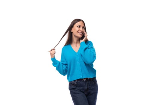 beautiful cute young woman dressed in a blue cardigan chatting on the phone.