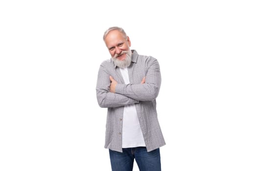 well-groomed senior man with a gray beard and mustache is dressed in a plaid shirt on a white background.
