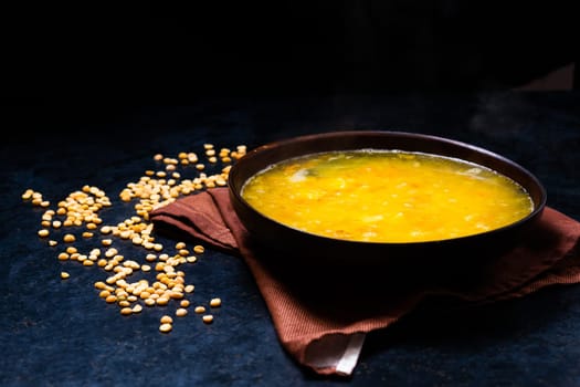 Appetizing hot pea soup and an onion served with slices of bread