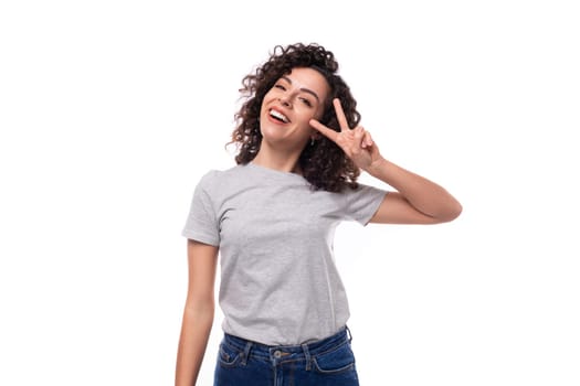 young slender brunette curly woman is dressed in a gray basic corporate color t-shirt. clothing identity and branding concept.