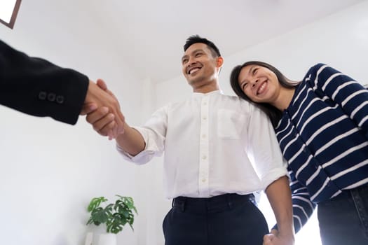 Couple asian handshake with a real estate agent after purchase a home.