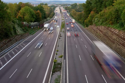 Night lights from car headlights on roundabout in night city. Traces of headlights on the road at night, long exposure. Drone aerial shot. Panoramic aerial view of illuminated road overpass and road junction. traffic lights traces cars top view road top view