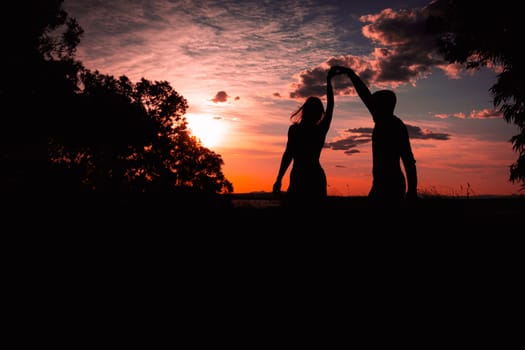 Couple dancing salsa at sunset,silhouette of couple in love at sunset against the backdrop of nature. High quality photo