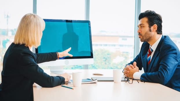 Business people in the conference room with green screen chroma key TV or computer on the office table. Diverse group of businessman and businesswoman in meeting on video conference call . Jivy