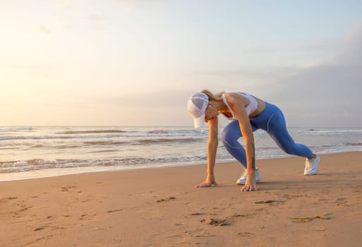 a girl at dawn doing exercises on the seashore in sportswear, there is a place for an inscription. High quality photo