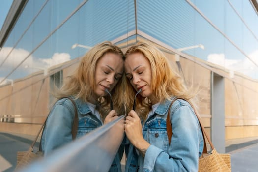 Portrait of a young woman in a denim jacket looking at a store window. High quality photo