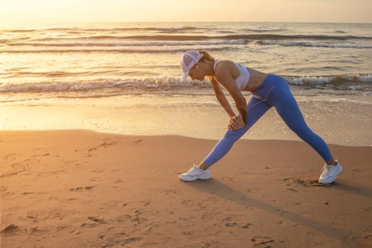 a girl at dawn doing exercises on the seashore in sportswear, there is a place for an inscription. High quality photo