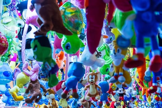 a lot of colored soft toys in a dash in the amusement park, there is a place for an inscription. High quality photo