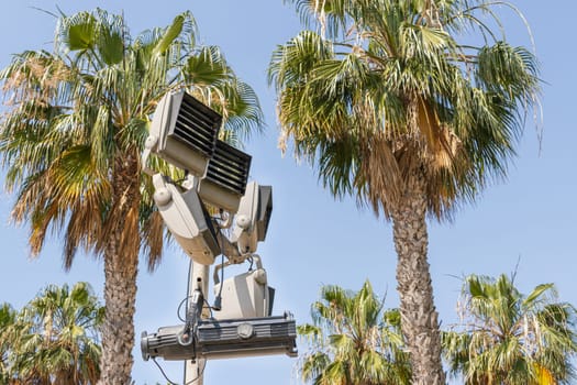 spotlights against a background of blue sky and green palm trees, close-up. There is a place for an inscription. High quality photo