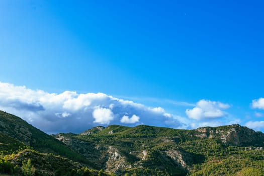 Photograph of a mountain landscape, view of a mountain with forest and clouds. High quality photo