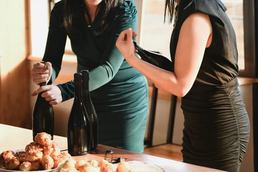 Girlfriends opening wine at a wedding