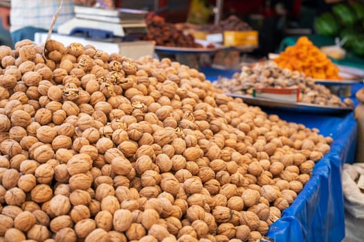 Walnut sale in the traditional farm Turkish market, a counter filled with fresh fruits