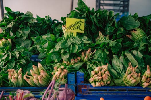 Fresh spinach sale in the traditional farm Turkish market, a counter filled with fresh fruits