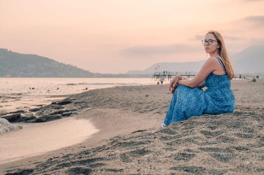 Woman sits on the beach and looks at the sea in Alanya city, Turkey. Travelling or vacation concept