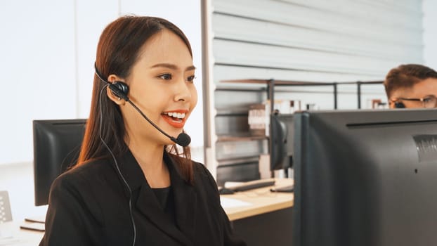 Business people wearing headset working in office to support remote customer or colleague. Call center, telemarketing, customer support agent provide service on telephone video conference call. Jivy