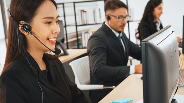 Business people wearing headset working in office to support remote customer or colleague. Call center, telemarketing, customer support agent provide service on telephone video conference call. Jivy