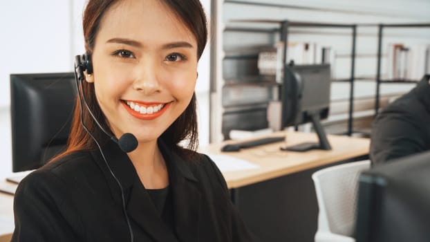 Business people wearing headset working in office to support remote customer or colleague. Call center, telemarketing, customer support agent provide service on telephone video conference call. Jivy