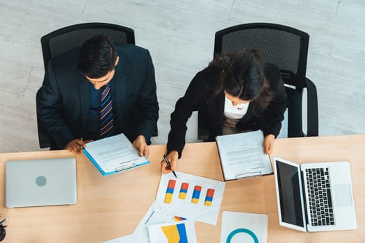 Business people group meeting shot from top view in office . Profession businesswomen, businessmen and office workers working in team conference with project planning document on meeting table . Jivy