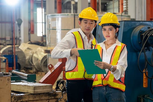 Professional quality control inspector conduct safety inspection on machinery and manufacturing process in factory. Engineers overseeing process optimization in heavy industry facility. Exemplifying