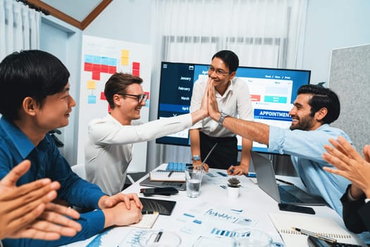 Happy office worker and project manager celebrate in meeting room after successfully achieving business task on time and on schedule. Project management tracking software for business success. Prudent