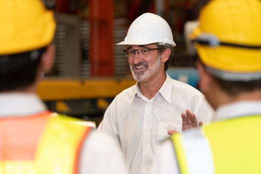Collective factory worker and engineer gather for meeting with factory executive or manager, discussing plan and industry training program on-site work heavy industrial steel workshop. Exemplifying