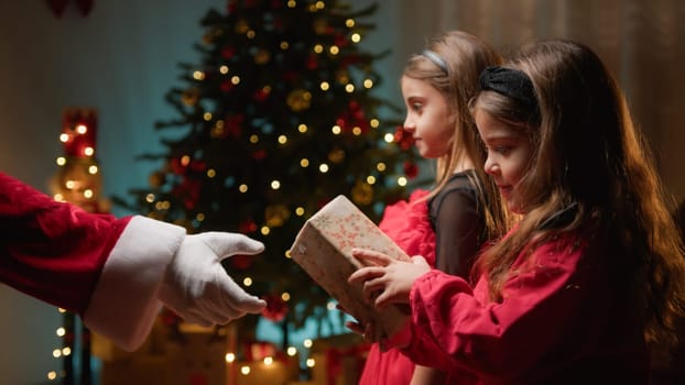 Little sisters receiving gifts from Santa Claus .