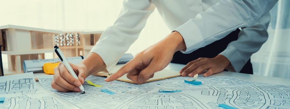 Worker, architect and engineer work on real estate construction project oratory planning with cartography and cadastral map of urban town area to guide to construction developer business plan of city