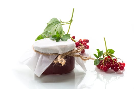 viburnum jam in a glass jar and fresh red viburnum isolated on a white background.