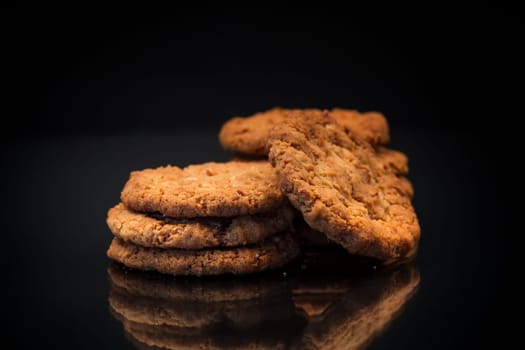 cooked sweet oatmeal cookies, isolated on black background