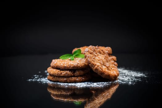 cooked sweet oatmeal cookies, isolated on black background