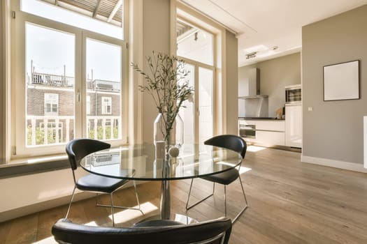 a living room with wood flooring and large windows looking out onto the cityscapearl view from the dining area