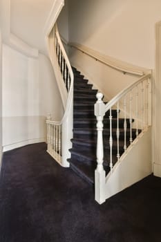 a white staircase with black carpet and wooden handrails in an empty living room photo taken from the inside