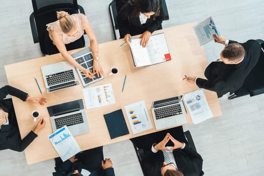 Business people group meeting shot from top view in office . Profession businesswomen, businessmen and office workers working in team conference with project planning document on meeting table . Jivy