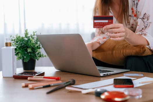 Young happy woman buy product by online shopping at home while ordering items from the internet with credit card online payment system protected by utmost cyber security from online store platform