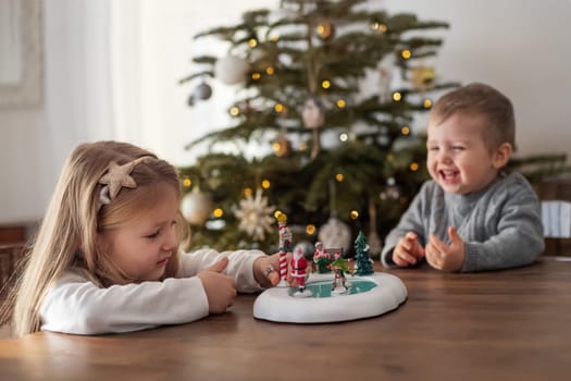 Sister and brother play with ceramic figures for Christmas