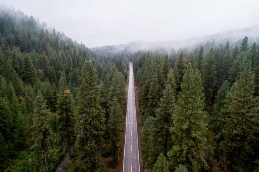 road going through a mountain pass with clouds showing in the sky