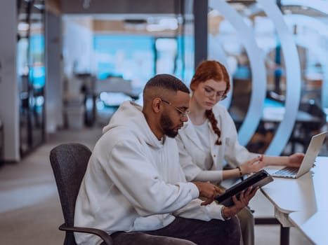 In a modern office setting, an African American businessman and his Muslim colleague, wearing a hijab, engage in collaborative discussions, tackling various business tasks and solving problems together, showcasing diversity, ambition, and teamwork in their dynamic and inclusive workplace