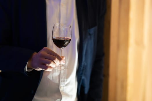 A hand delicately grasping a wine glass, capturing a moment of indulgence.