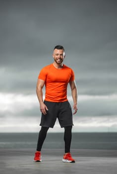 Athletic man doing sports exercises on the ocean.